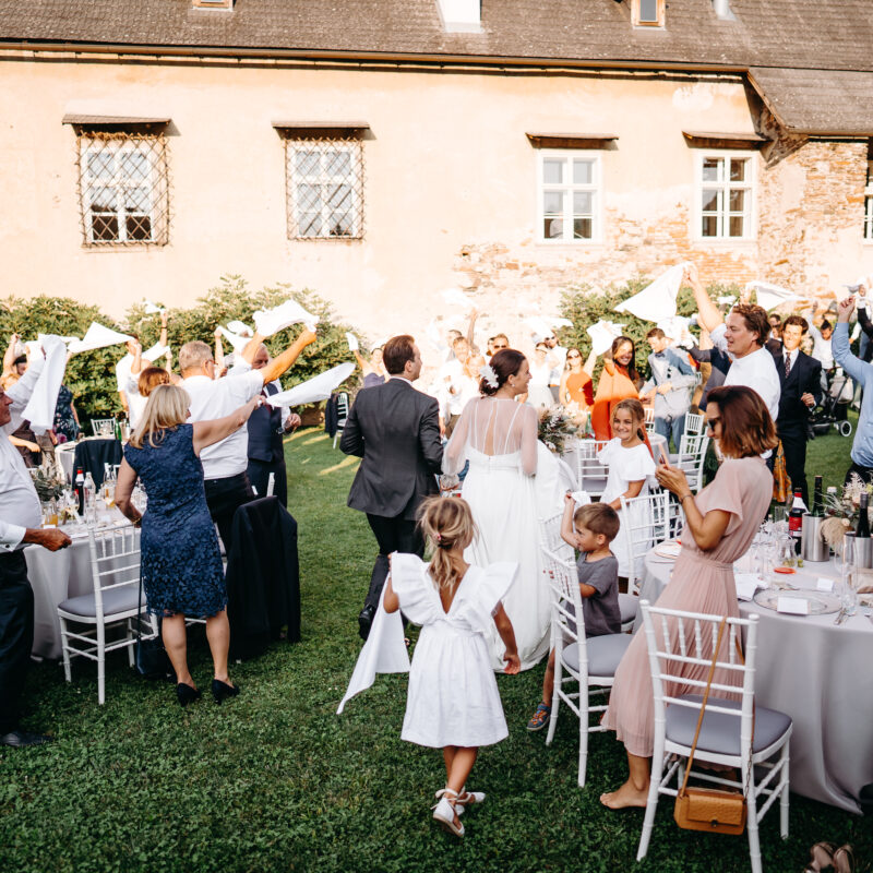 Brautpaar und Gäste in action beim Outdoor-Dinner