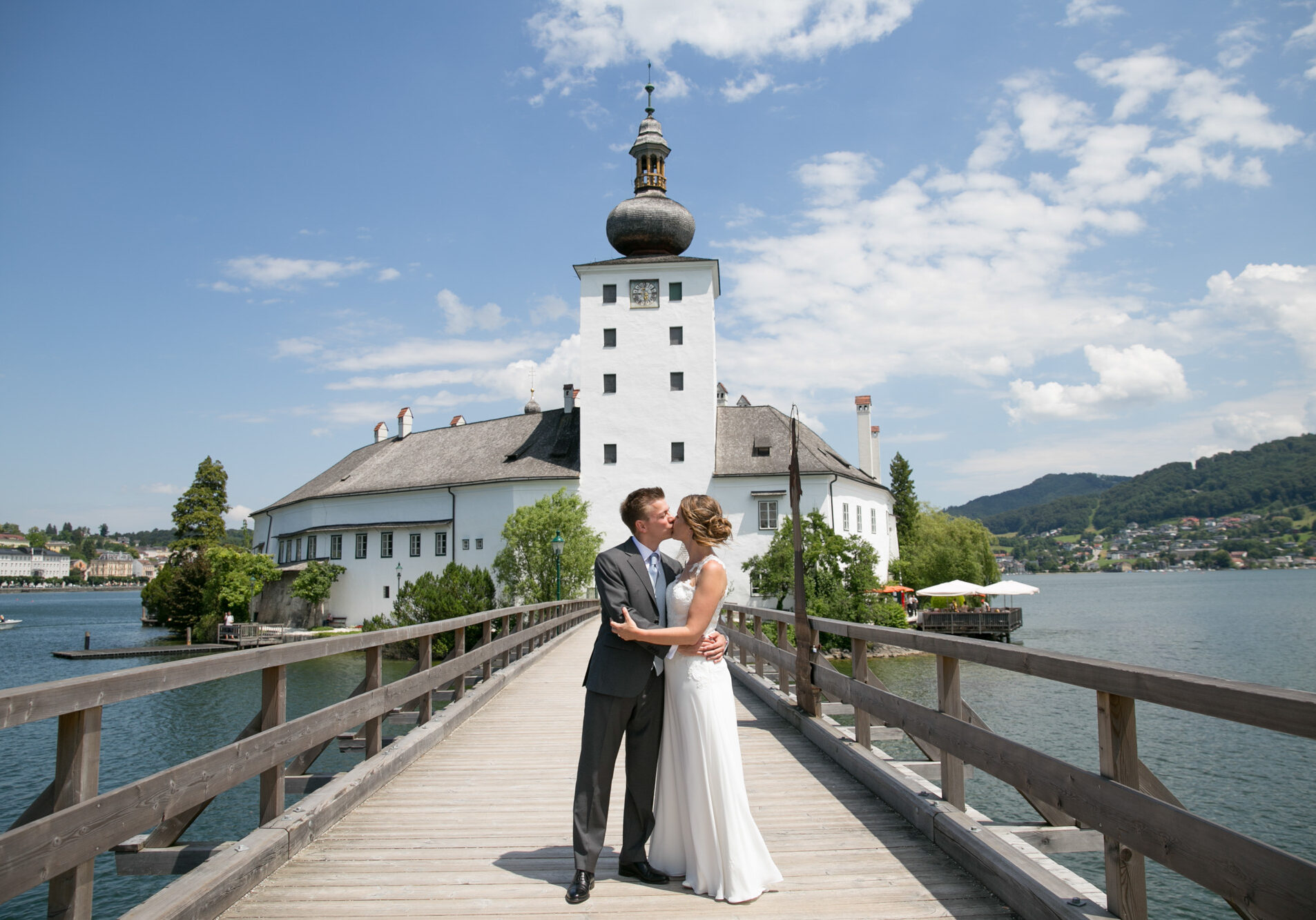 Hochzeitspaar küssend vor einem Schloss